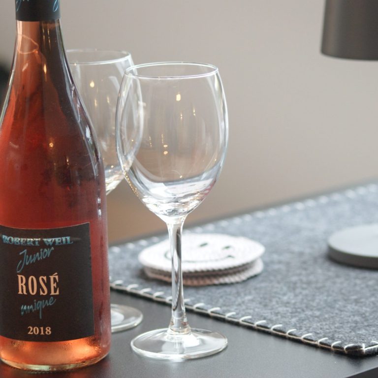 Eine Flasche Rosé und zwei Weingläser auf dem Tresen der Küche.