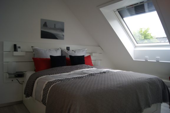 Blick ins frisch bezogene Schlafzimmer 1 mit schrägem und verdunkelbarem Fenster